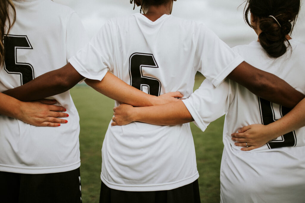 Children in jerseys with arms around each other