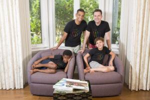 David Dinan and Vikranth (“Vik”) Gongidi pose for a photo in their home with their children