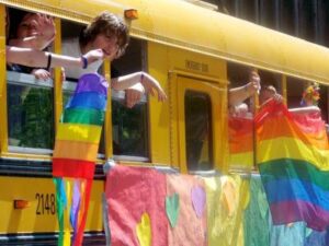 Students hold pride flags outside of a school bus to protest banning of Gay Straight Alliances