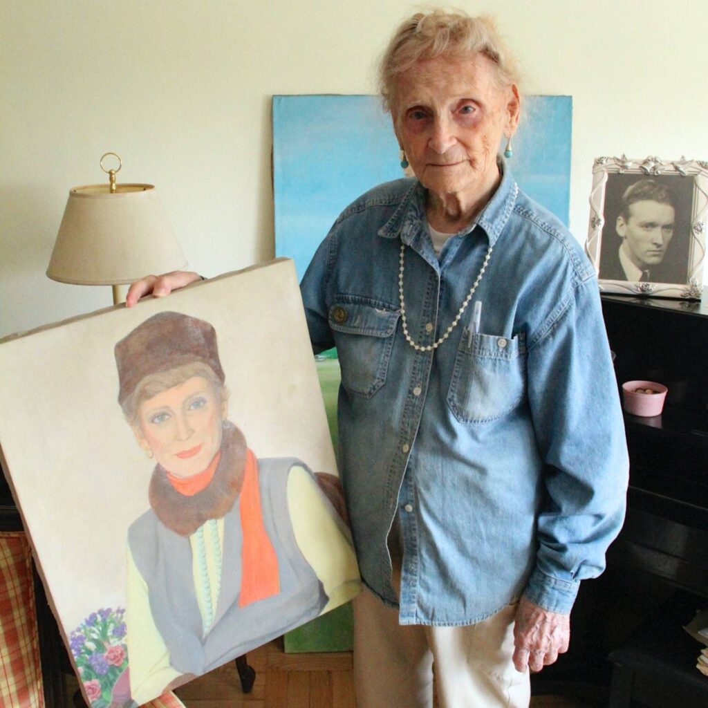Transgender veteran Robina Asti poses with portraits in her home.