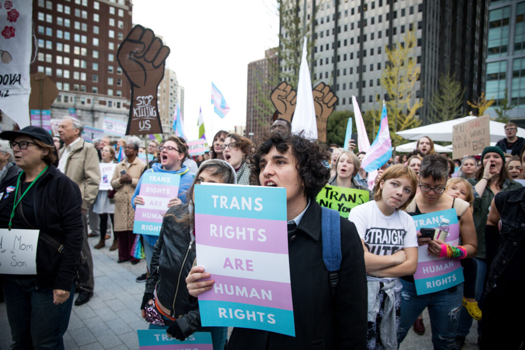 Protesters in Philadelphia, PA, hold up signs that read "Trans Rights are Human Rights"