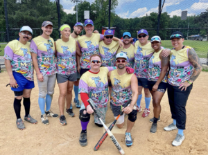 Sasha Buchert posing with DC National Mall Rats sports team on the field in 2023